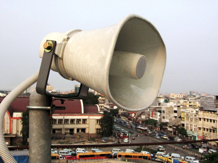 a large bullhorn is attached to a pole near a road