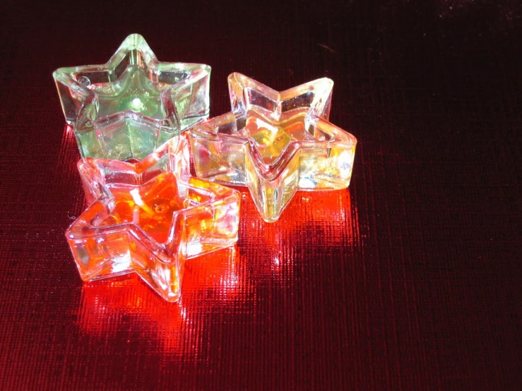 an assortment of glass stars on a red cloth