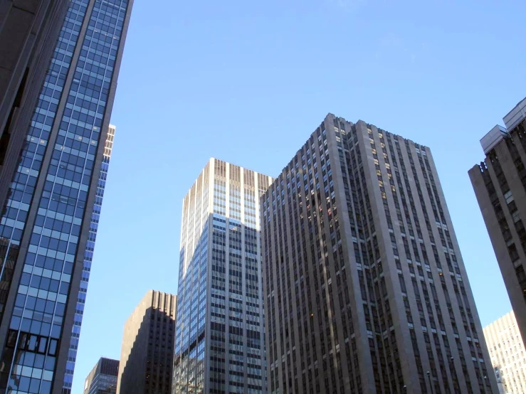 the skyscrs of buildings in the city are shown against a blue sky