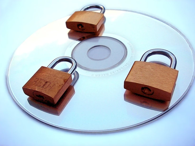 three padlocks on top of a cd