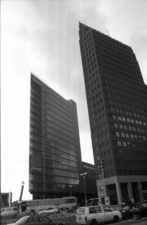 two very tall buildings with a parking lot below