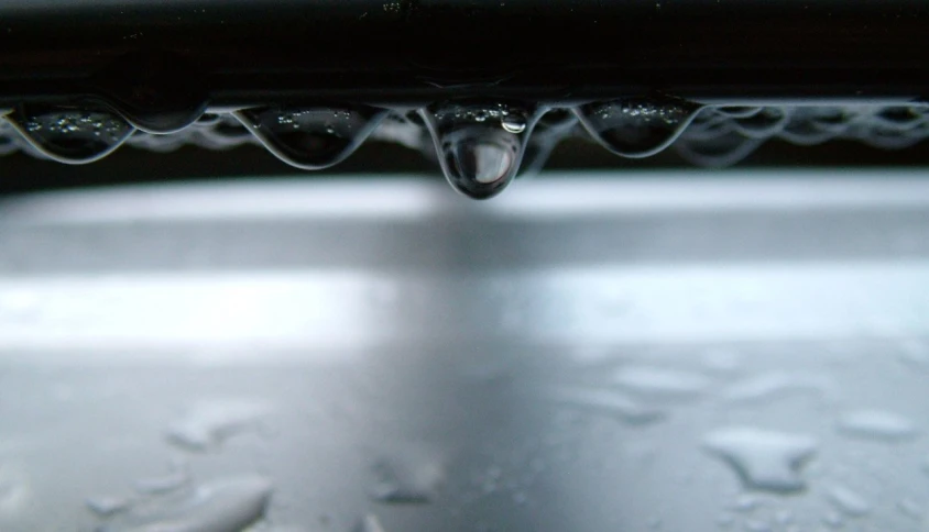 drops of water fall on the top of an umbrella