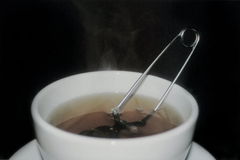 a cup of tea with a metal stir top