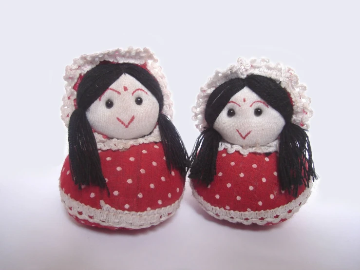 two dolls in red and white are facing each other