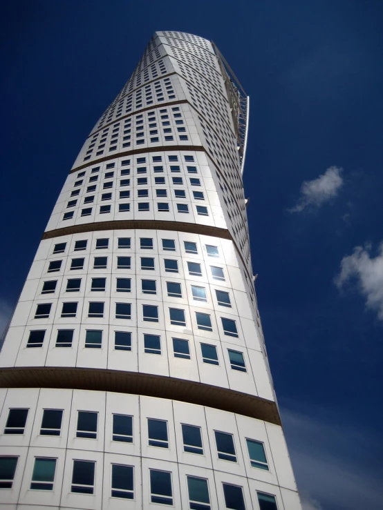 a tall white building with many windows under the clouds