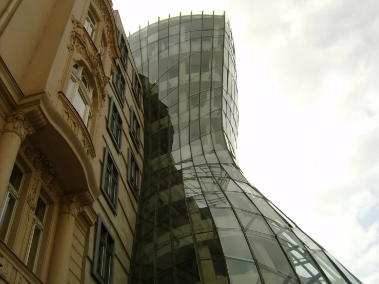 the side of a building with windows and the sky behind