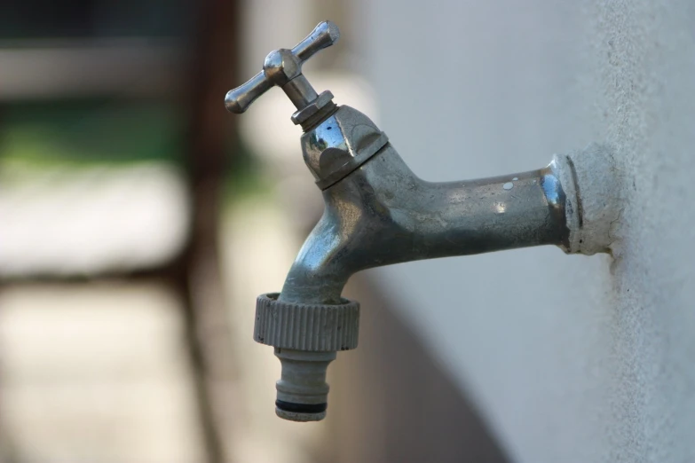 a faucet attached to a wall with some metal fittings