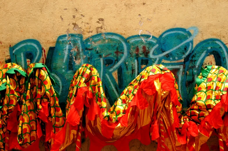 colorful clothing hanging in front of a wall with graffiti
