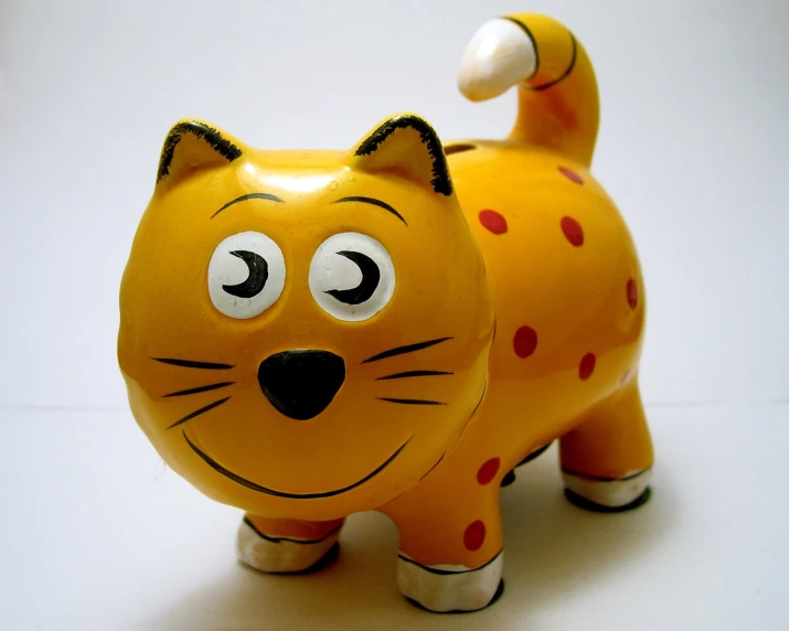 a plastic cat is painted orange and black with polka dot spots