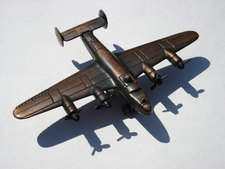 a metal toy plane on a white surface