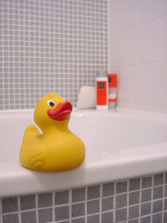 a rubber ducky on a white tile bathtub