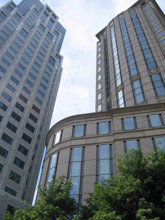 two buildings on a street with green trees