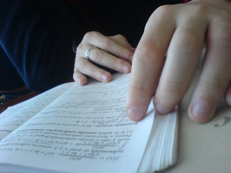 two hands hold a book together with the pages lined in