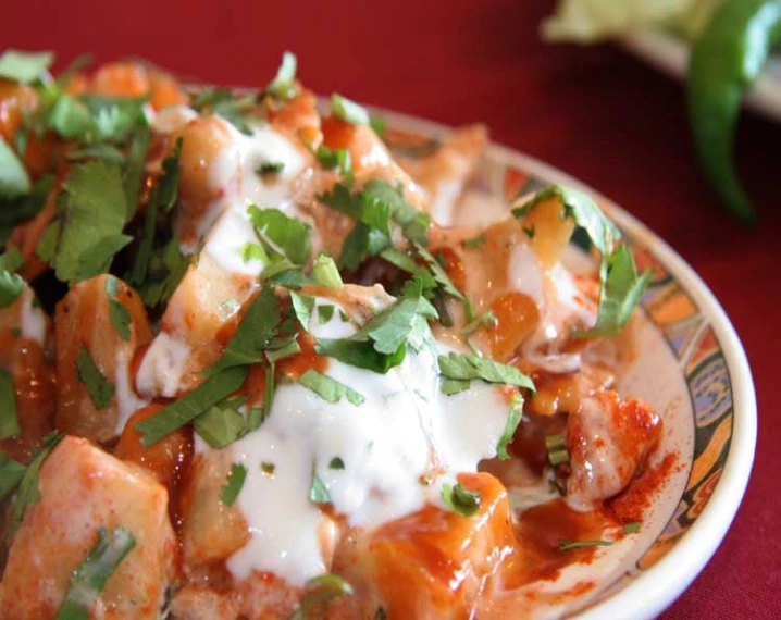 a bowl full of food that includes meat, cheese and sauce