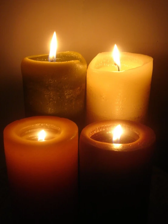 five candles lit in a row on a dark background