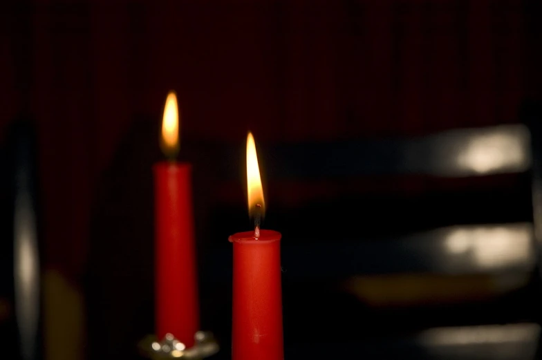 red candles stand tall at the top of a black table