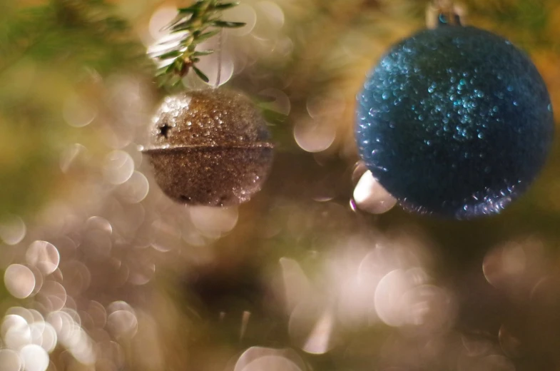 two christmas balls are hanging from a tree