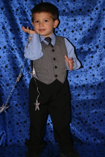a little boy in a suit is holding on to the necktie