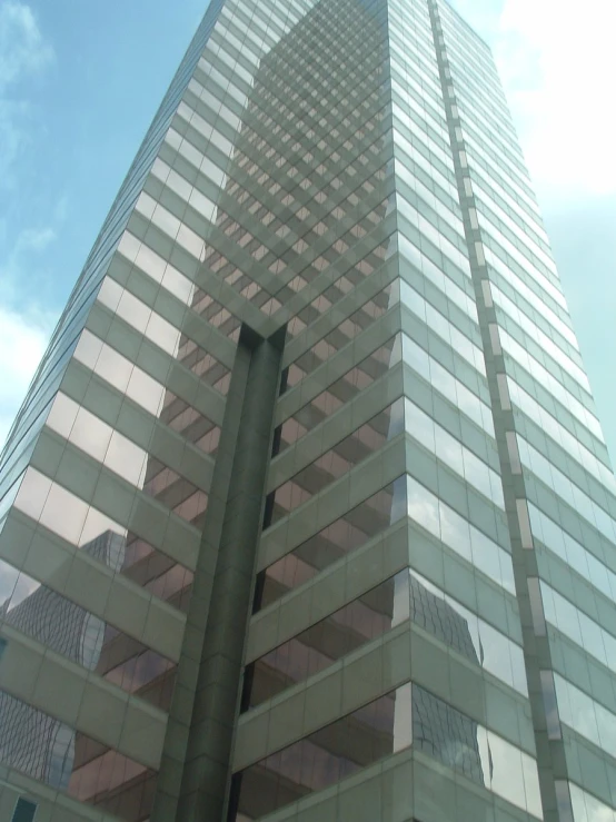 the top of a tall glass building that has windows