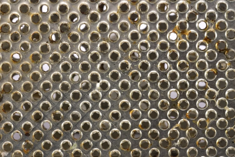 a metal surface with circles of varying sizes