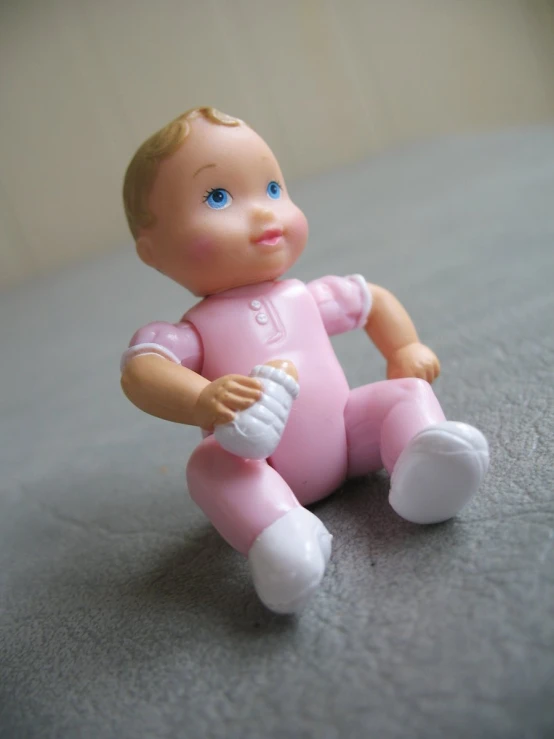 toy doll sitting on grey blanket with open eyes