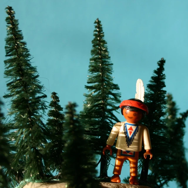 toy soldier standing by evergreen trees in the woods
