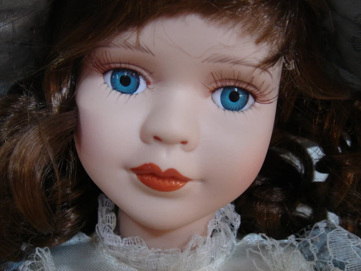 a doll with large blue eyes and an orange lip