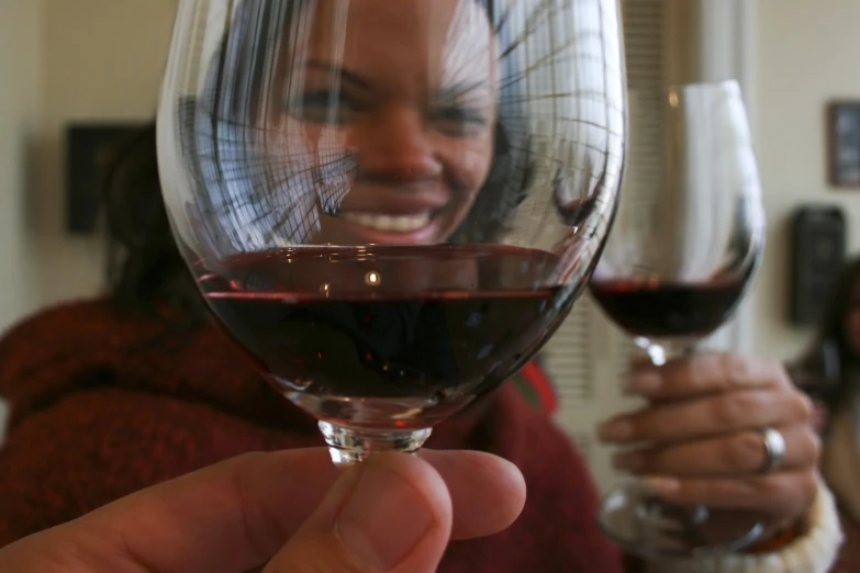 a woman is smiling and holding a wine glass