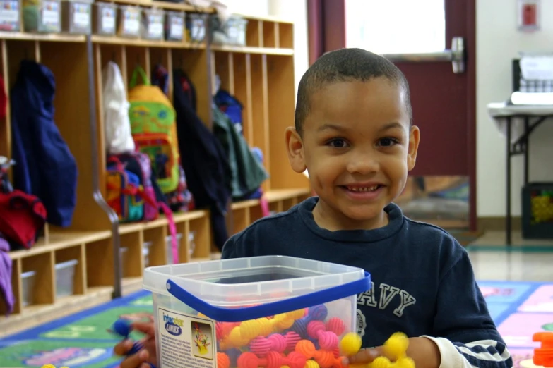 a boy smiling with some colorful balls in his hands