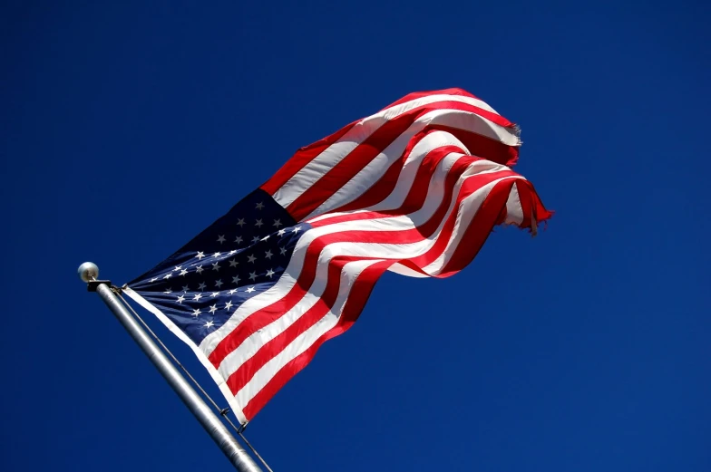 the american flag flies in the breeze on a clear day