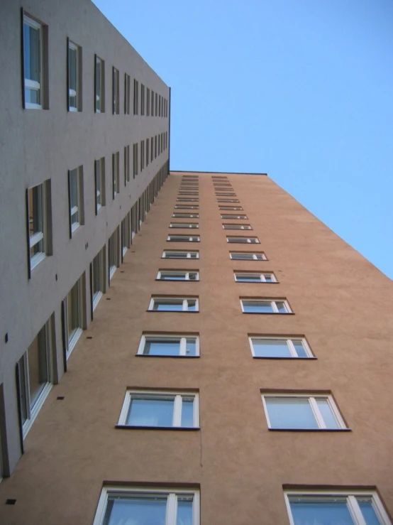 the side of a building with windows and a sky background