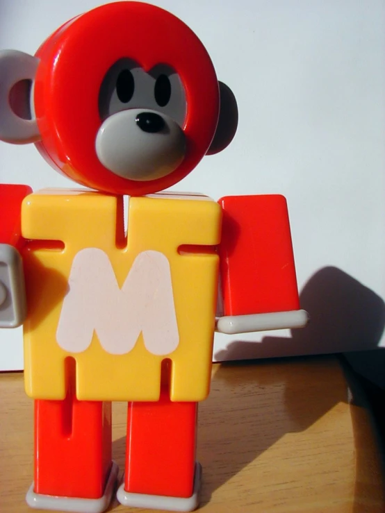 a plastic toy bear with a missing piece standing up on a table