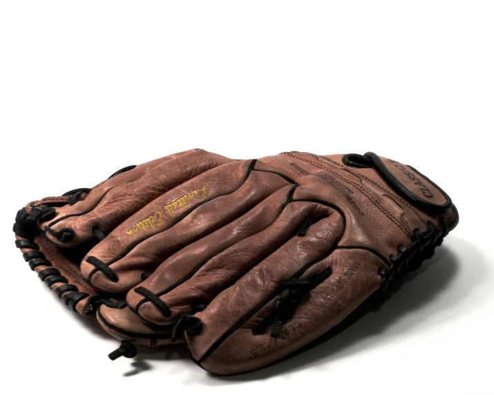 an old baseball mitt sitting on a white surface