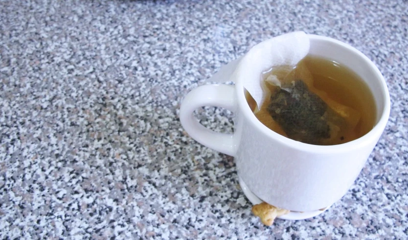 a cup filled with tea sitting on top of a counter