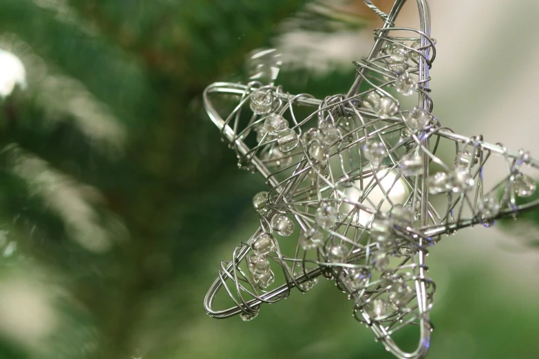 a silver christmas ornament with a glass star