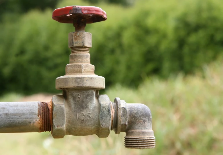 close up of pipe connecting to water tap on field