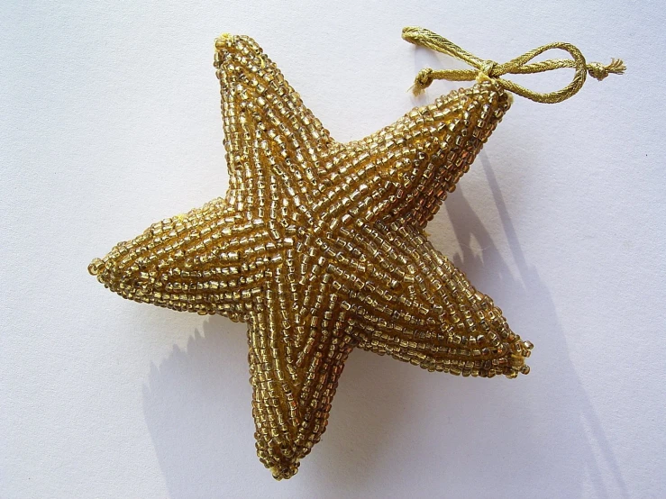 a large gold star ornament hanging from a string