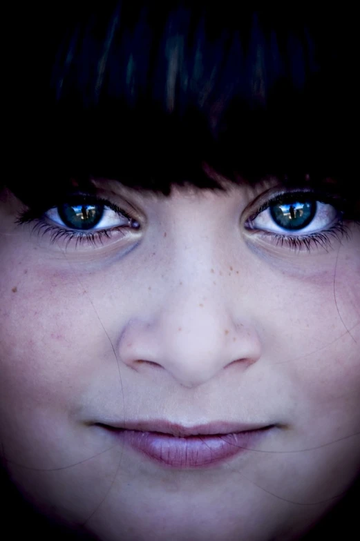 a close up of a young person with blue eyes