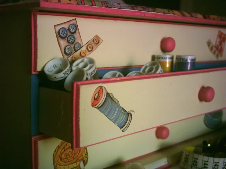 an old dresser painted like a colorful sewing case