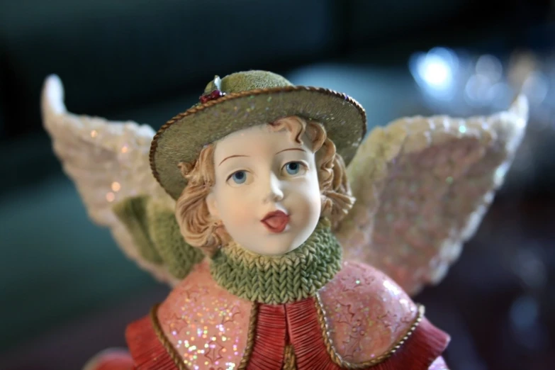 an angel figurine in a hat and red dress