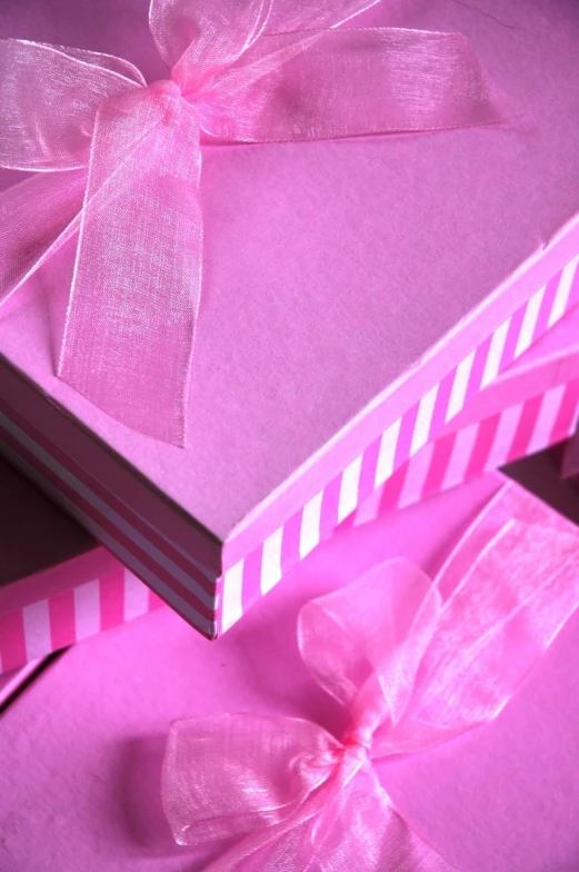 a pink ribbon and bow on two large books