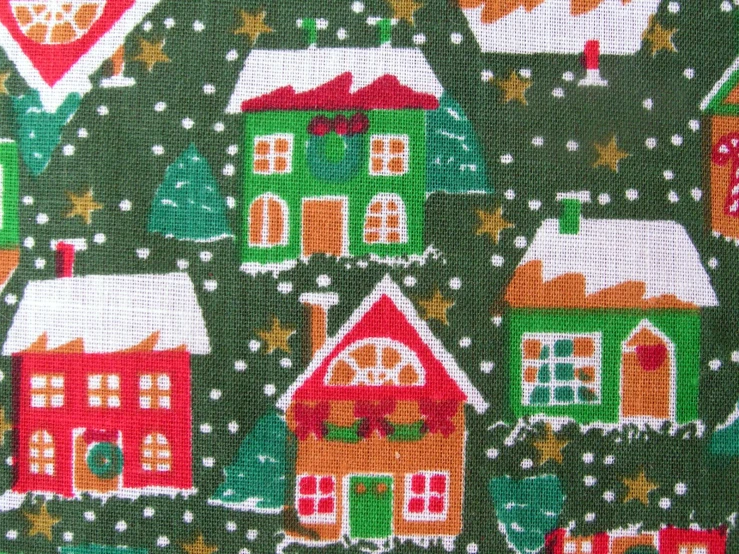 a multicolored christmas fabric featuring small houses and snow