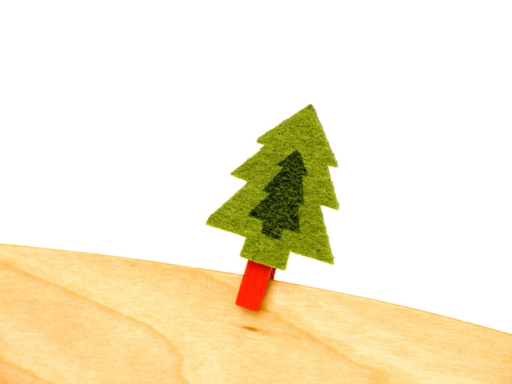 a green tree sitting on top of a wooden stand