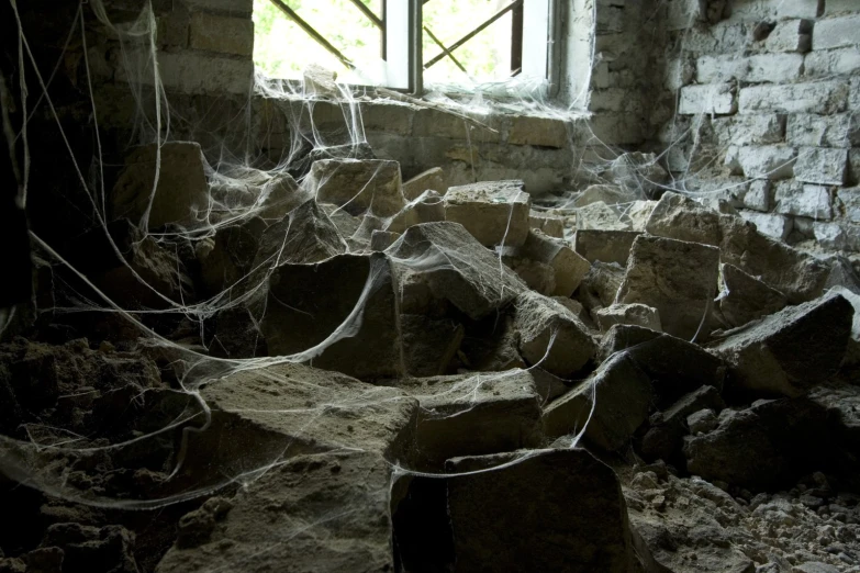 a window in a stone building with lots of spider webs