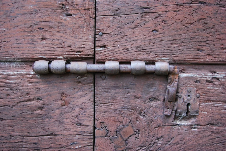 a old and weathered wooden door with a bolt