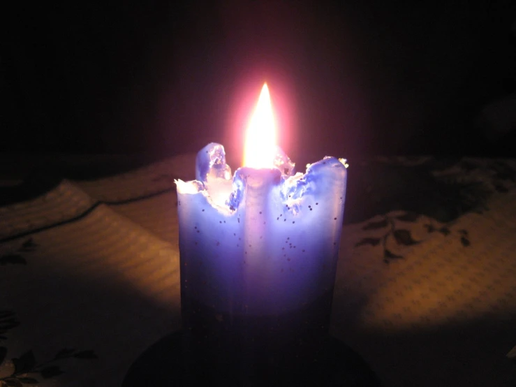 a single candle with blue frosting on the surface