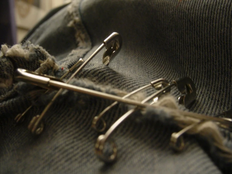 silver scissors laying on an old pair of jeans