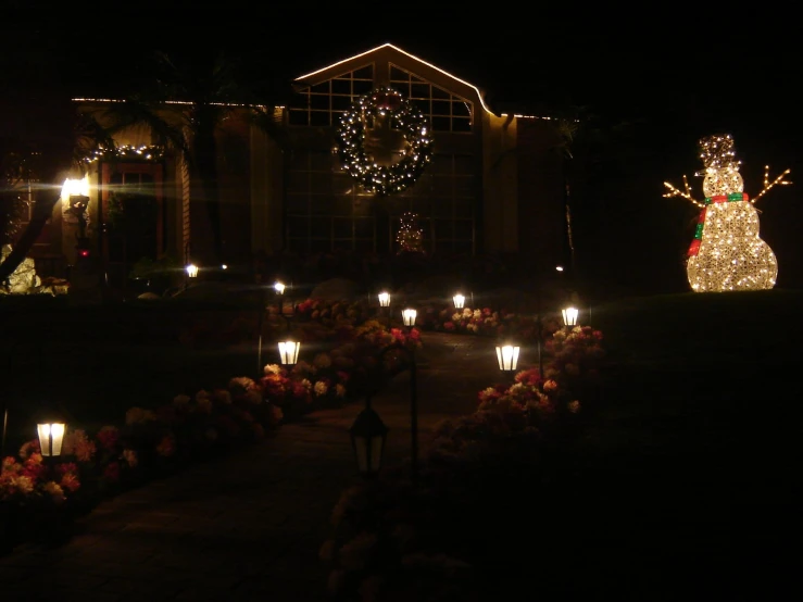 lighted candles in front of a lighted christmas tree and a lit up snowman