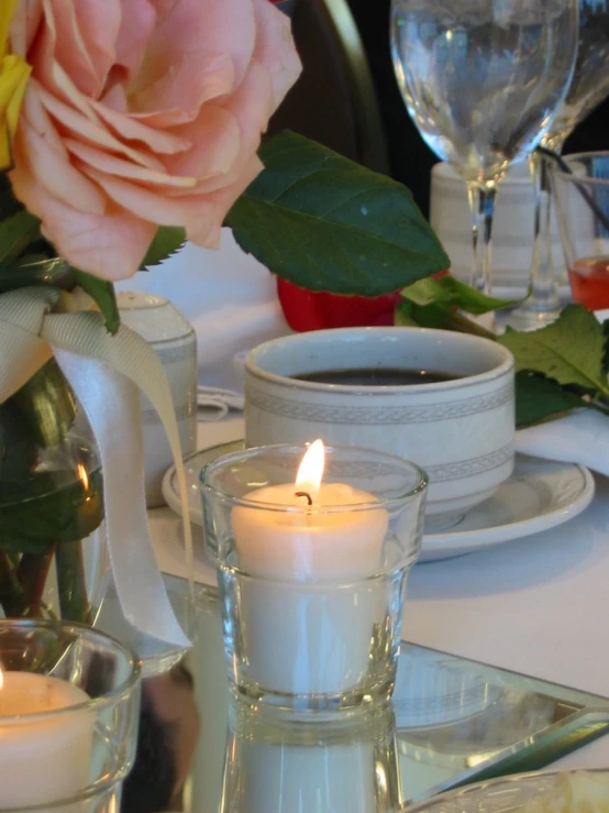 a lit candle sitting on top of a table next to some plates