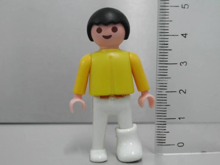 a toy figure is next to a measuring stick